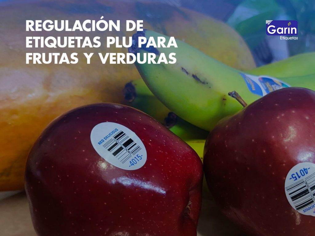 Detalle de etiquetas PLU para frutas y verduras colocadas sobre dos manzanas y un plátano