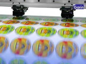 Detalle de una máquina haciendo impresión digital de etiquetas a gran velocidad.